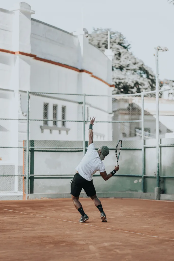 man serving on clay